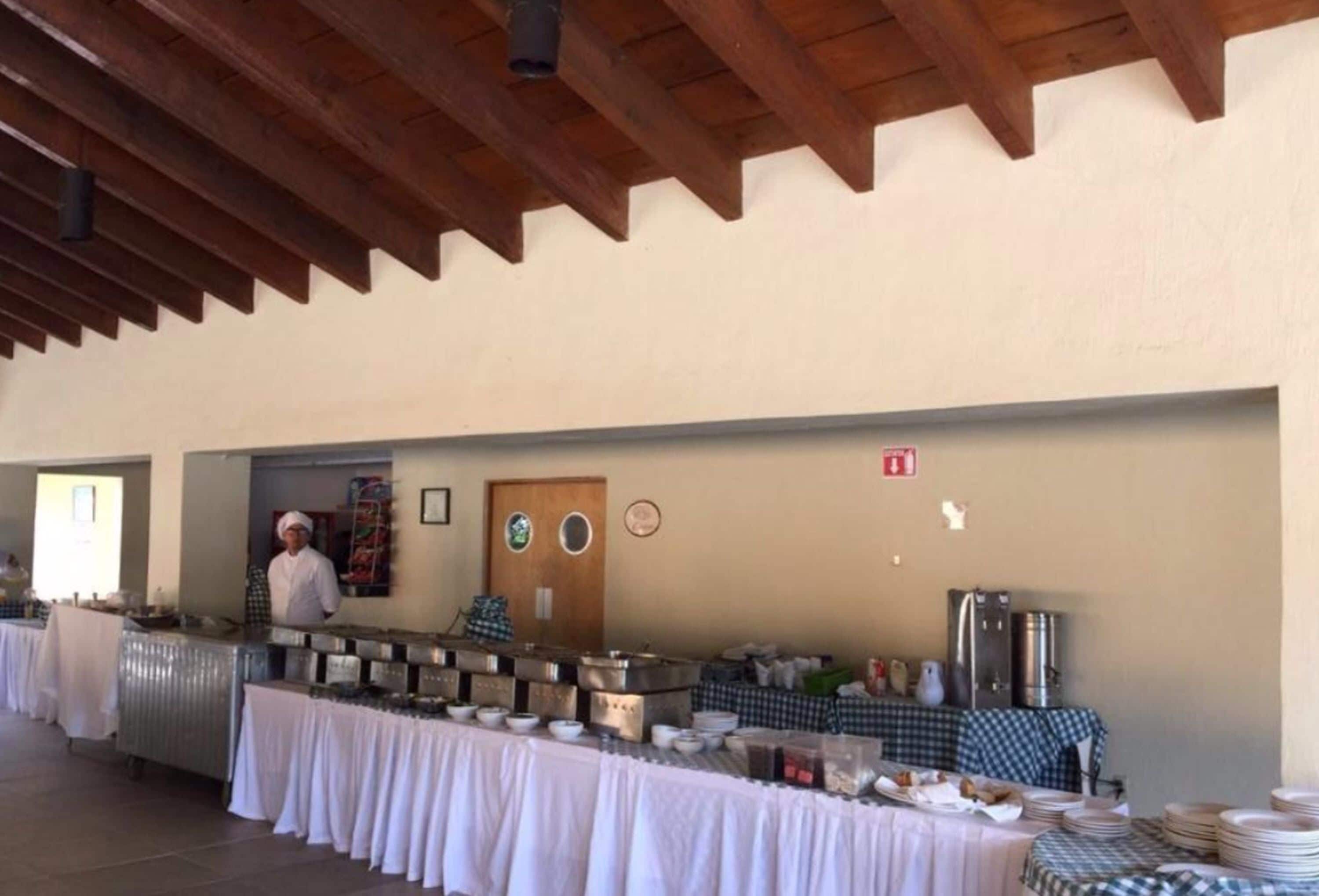 Un buffet avec un chef, des appareils en acier inoxydable et une nappe à carreaux.