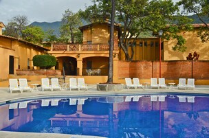 A pool area with white lounge chairs and a reflection pool.