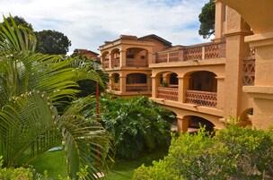 A multi-story building with a courtyard, featuring arched balconies and a brick facade.