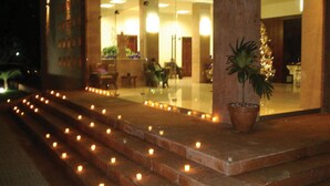 A hotel entrance with a staircase lit by candles, a potted plant, and a Christmas tree. - Hotel Poza Rica Inn (Poza Rica)