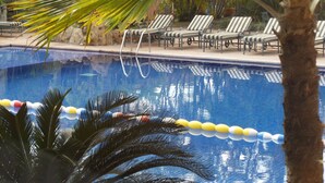 A swimming pool with lounge chairs and palm trees. - Hotel Poza Rica Inn (Poza Rica)