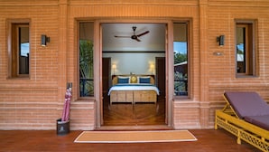 A hotel room with a bed, a ceiling fan, and a balcony with a lounge chair. - Bagan Lodge (Nyaung-U)