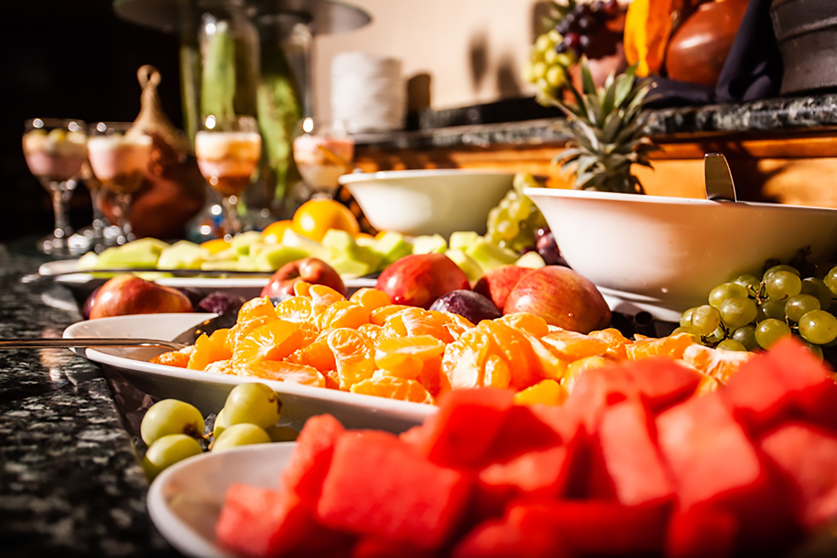 Uma mesa com várias frutas e uma taça de uvas.