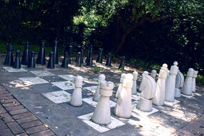 A large outdoor chessboard with chess pieces arranged in a game setting. - Avani Maseru Hotel (Maseru)
