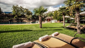 A poolside area with lounge chairs, a small hut, and a clear view of a swimming pool. - Avani Maseru Hotel (Maseru)