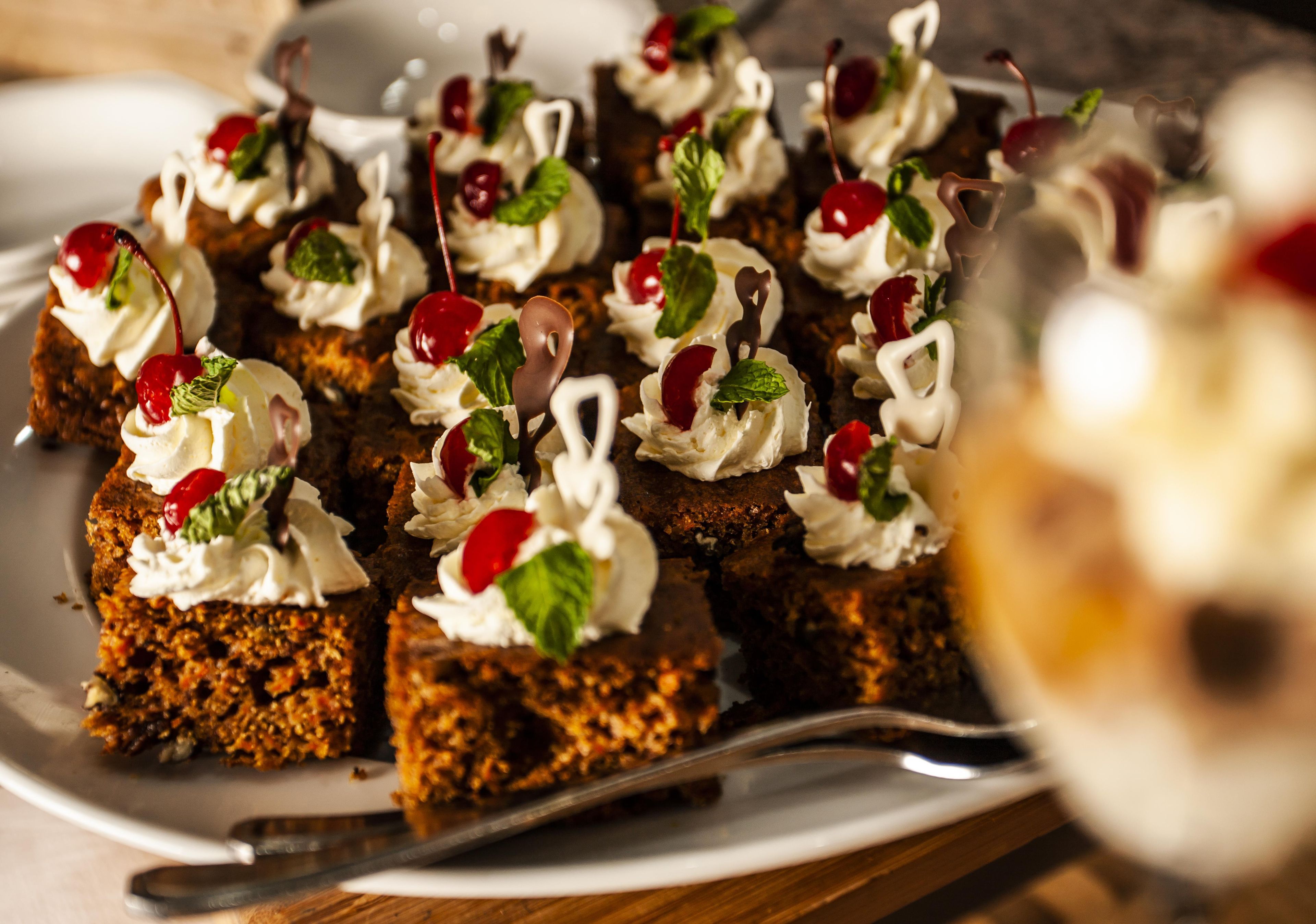 A plate of dessert with whipped cream and cherries.
