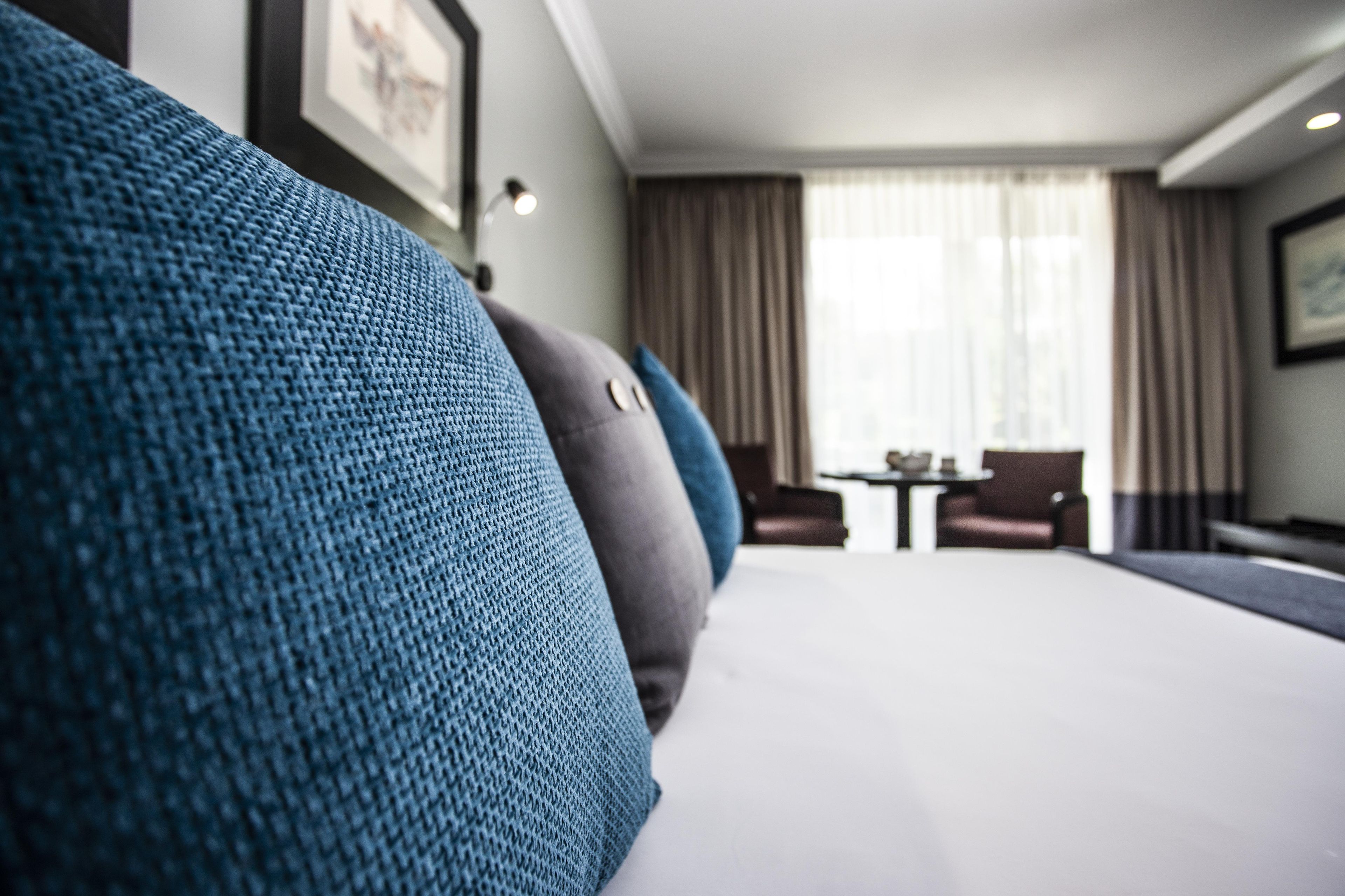 Ett hotellrum med en stor säng, ett litet bord och en stol.