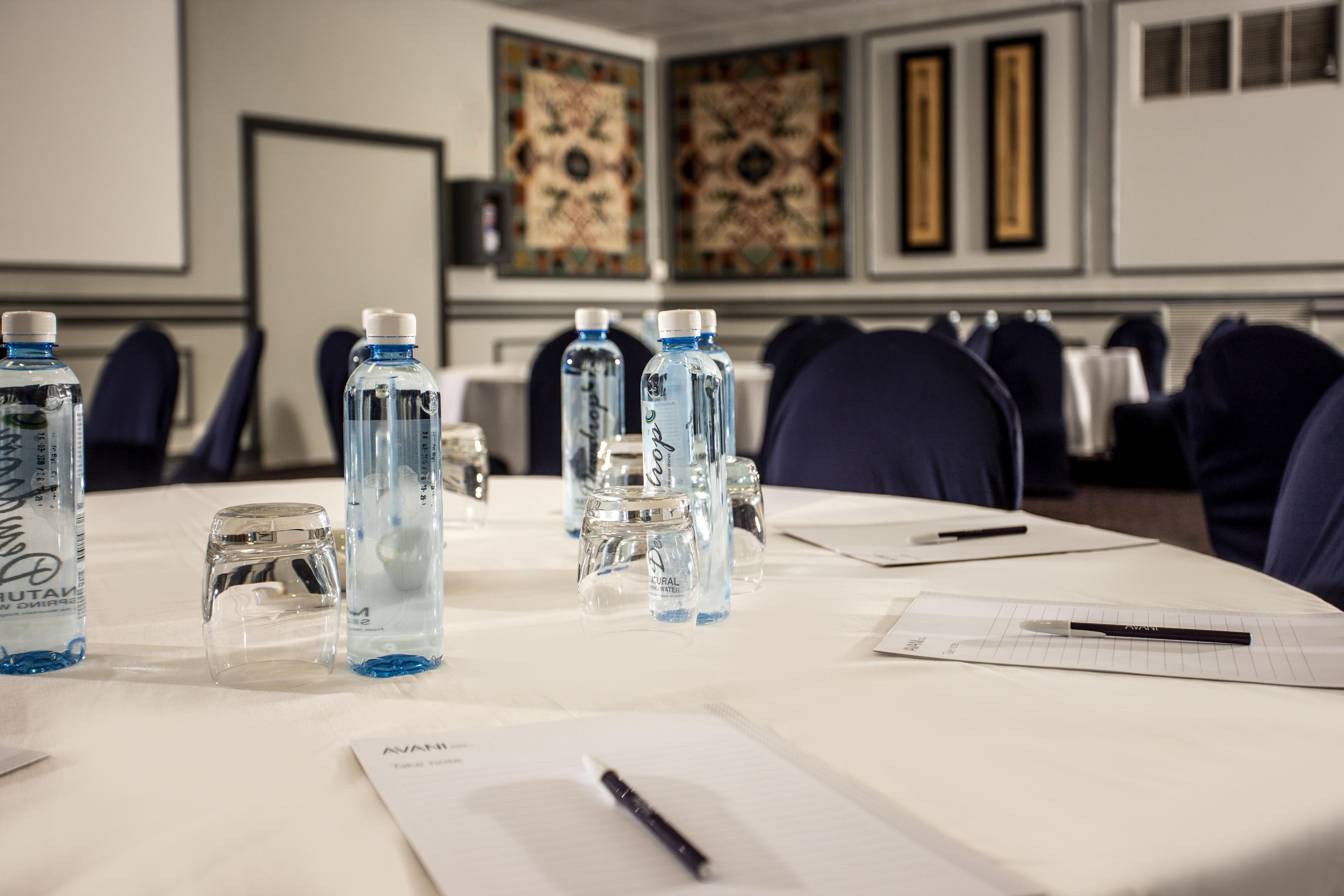 A conference table with water bottles, glasses, and documents.