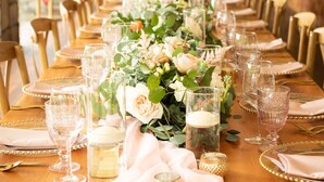 A long dining table set with glassware, plates, and a centerpiece of flowers and greenery. - The Inn at Thorn Hill & Spa (Jackson)