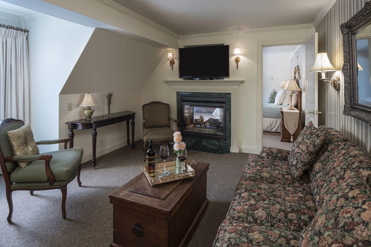 A living room with a fireplace, a television, a sofa, a chair, and a coffee table.