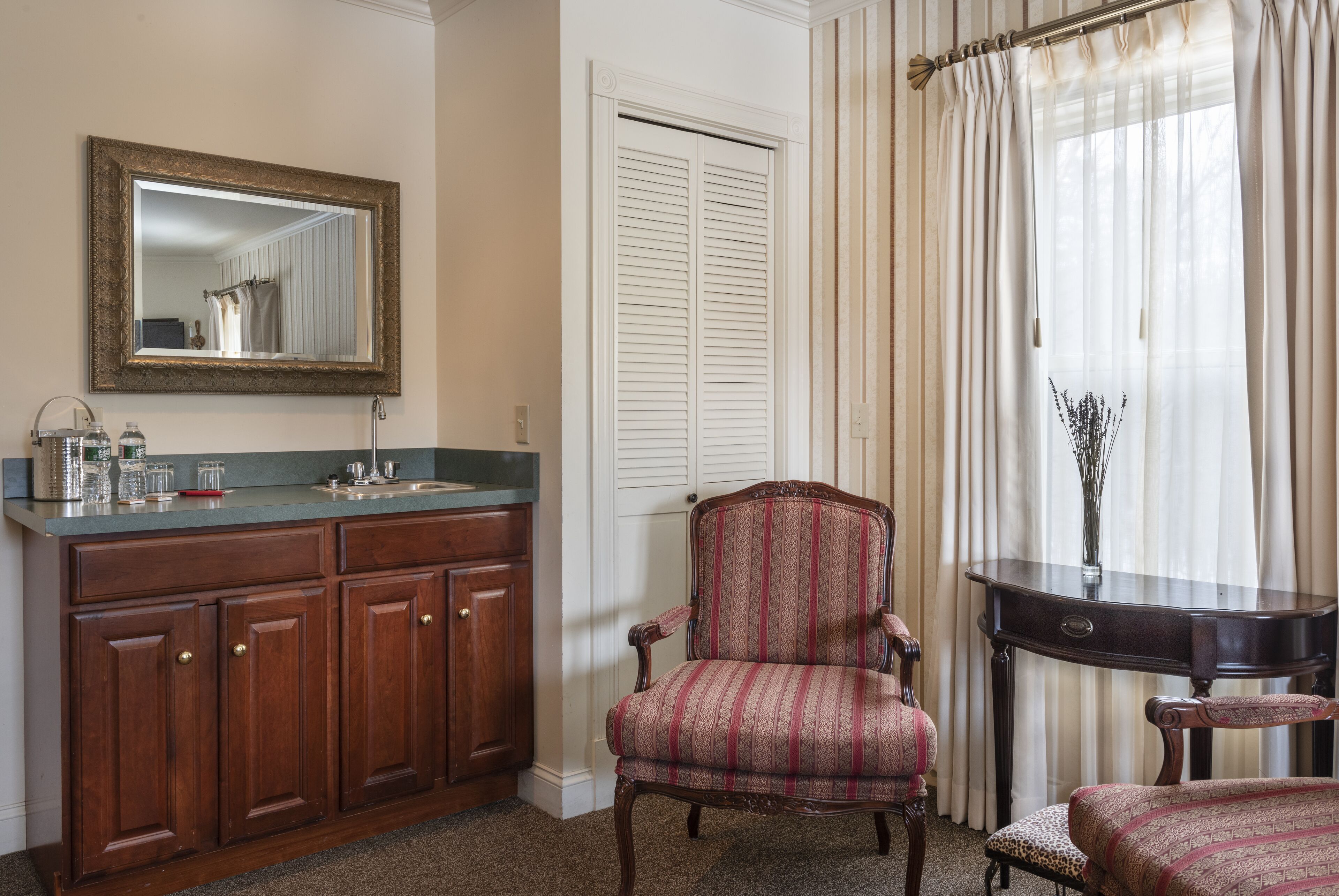 Une salle de bain avec un meuble-lavabo en bois, un miroir et une fenêtre avec des rideaux.