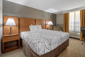 A hotel room with a large bed, two bedside tables with lamps, a chair, and a window with curtains. - Best Western La Plata Inn (La Plata)