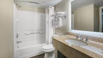 Une salle de bain avec une baignoire, des toilettes et un lavabo avec un miroir.
