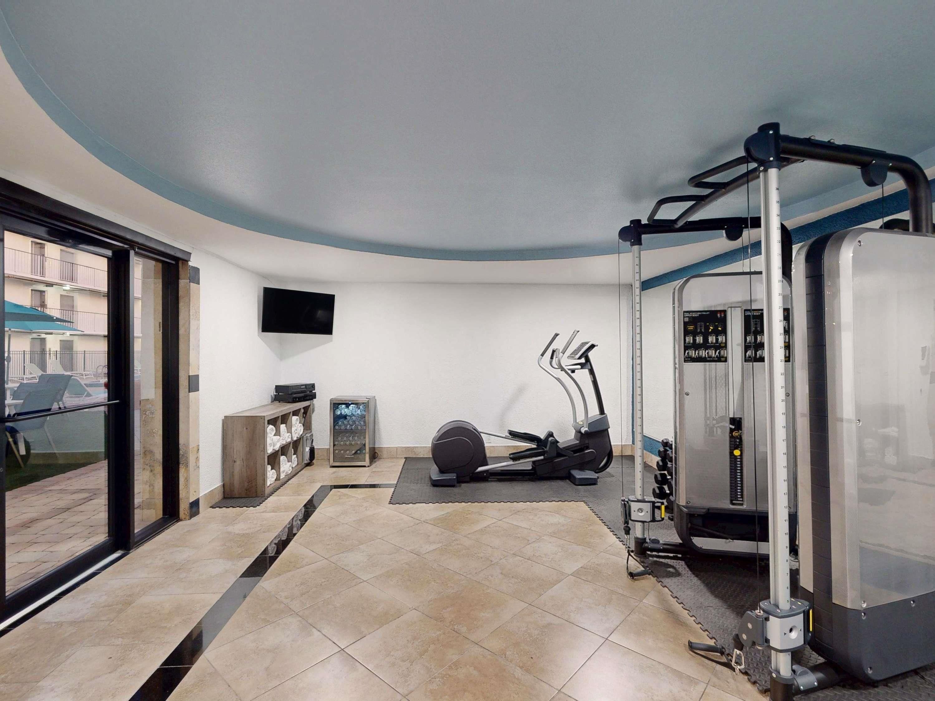 A gym with exercise equipment, a television, and a vending machine.