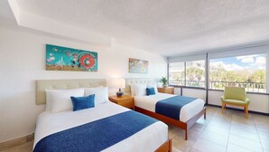 A hotel room with two beds, a large window, and artwork on the walls. - Park Royal Orlando managed by Accor (Kissimmee)