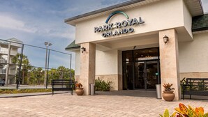The entrance of Park Royal Orlando with a paved walkway, potted plants, and a bench. - Park Royal Orlando managed by Accor (Kissimmee)
