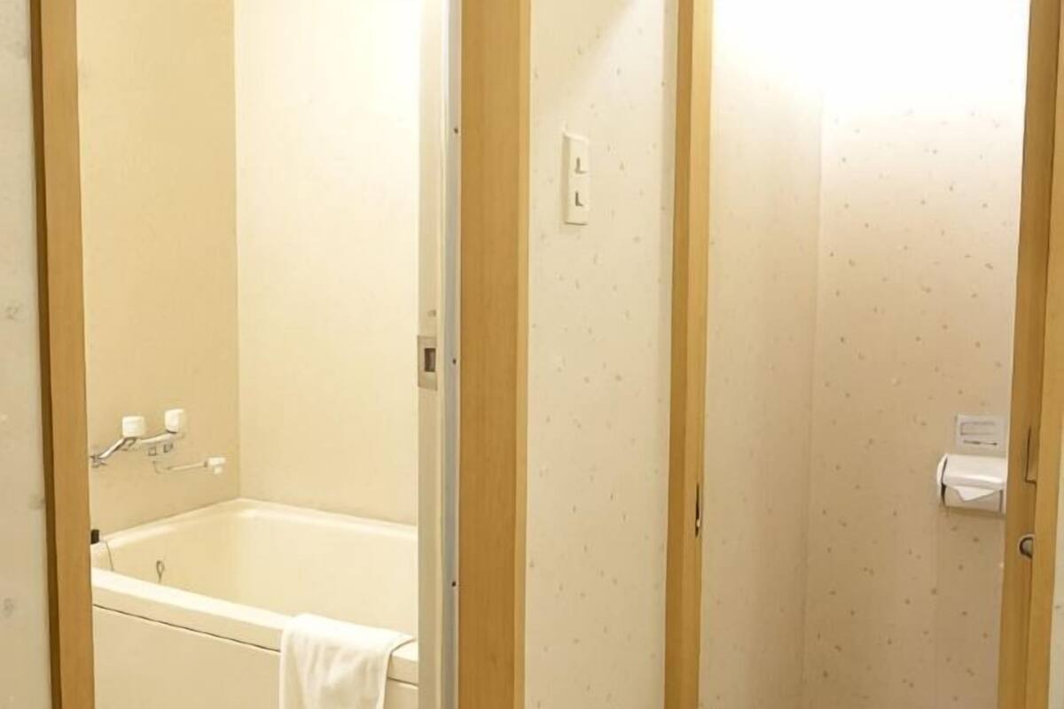 Ein Badezimmer mit einer Badewanne, einer Toilette und einem Handtuchhalter.