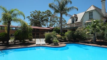 Una piscina al aire libre, tumbonas