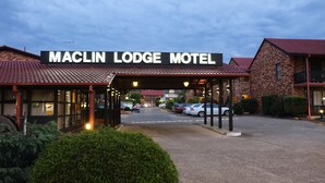 The Maclin Lodge Motel with a covered entrance, brick buildings, and a parking area. - Maclin Lodge Motel (Campbelltown)