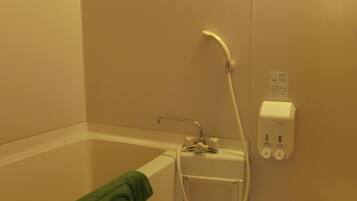 Un baño con bañera, ducha e inodoro.