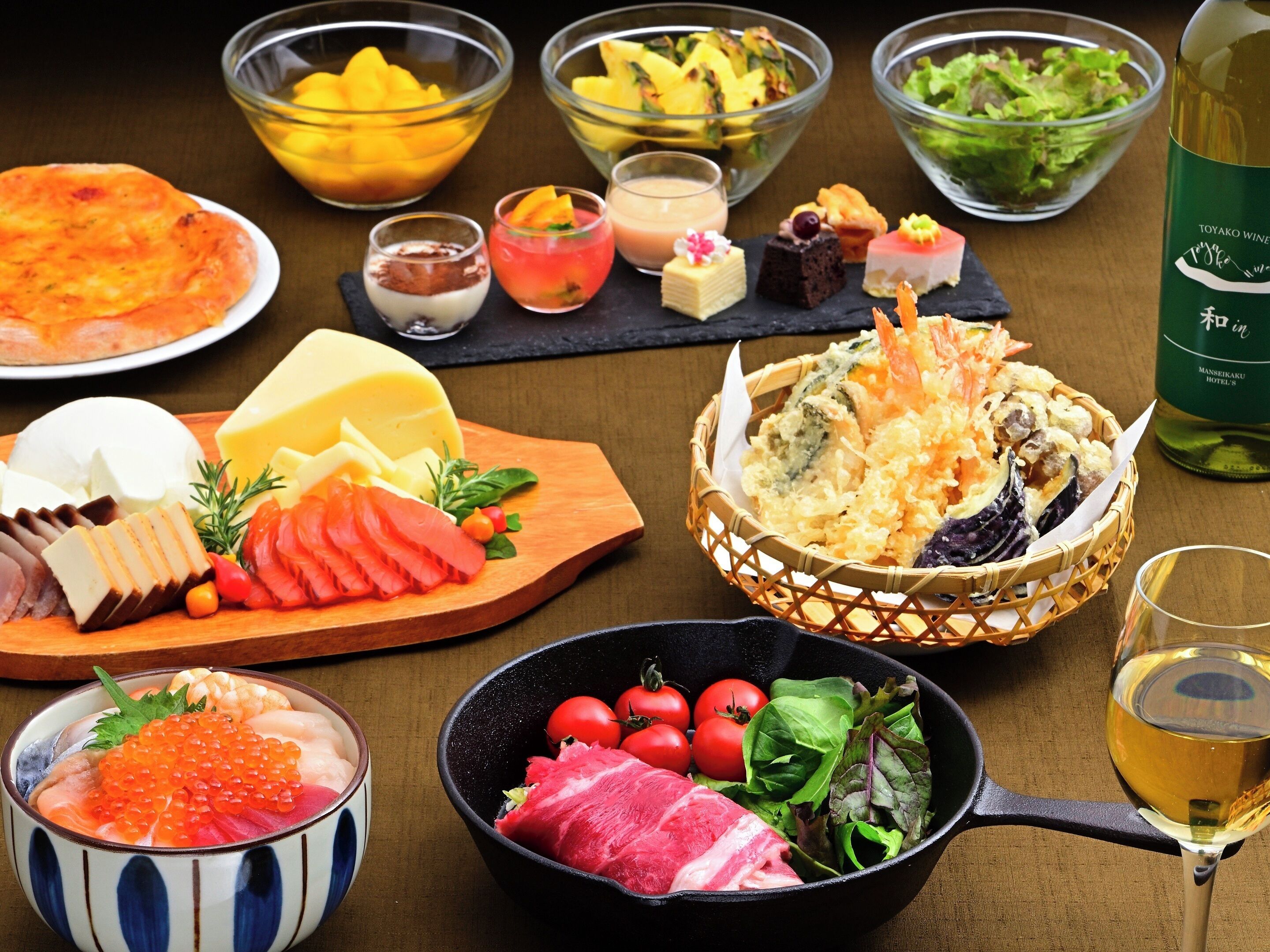 A variety of dishes including sashimi, cheese, and a bowl of vegetables.