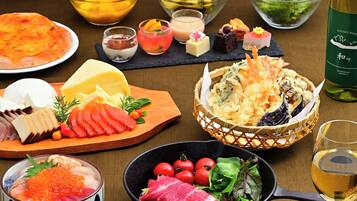 A variety of dishes including sashimi, cheese, and a bowl of vegetables.