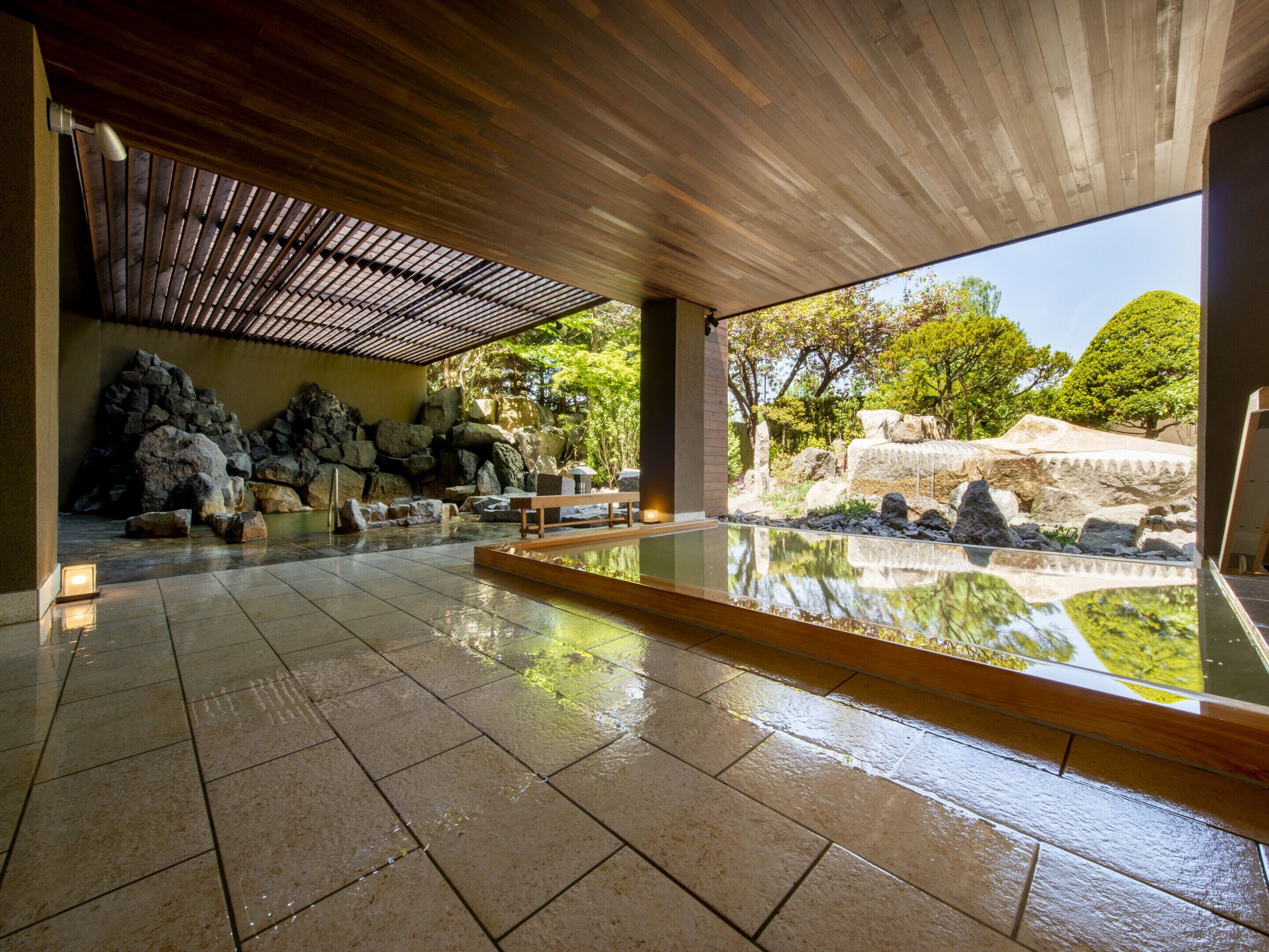 A serene indoor garden with a koi pond, stone arrangements, and a wooden ceiling.