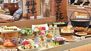 Een buffet met diverse gerechten en drankjes, waaronder sushi, salades en zeevruchten.
