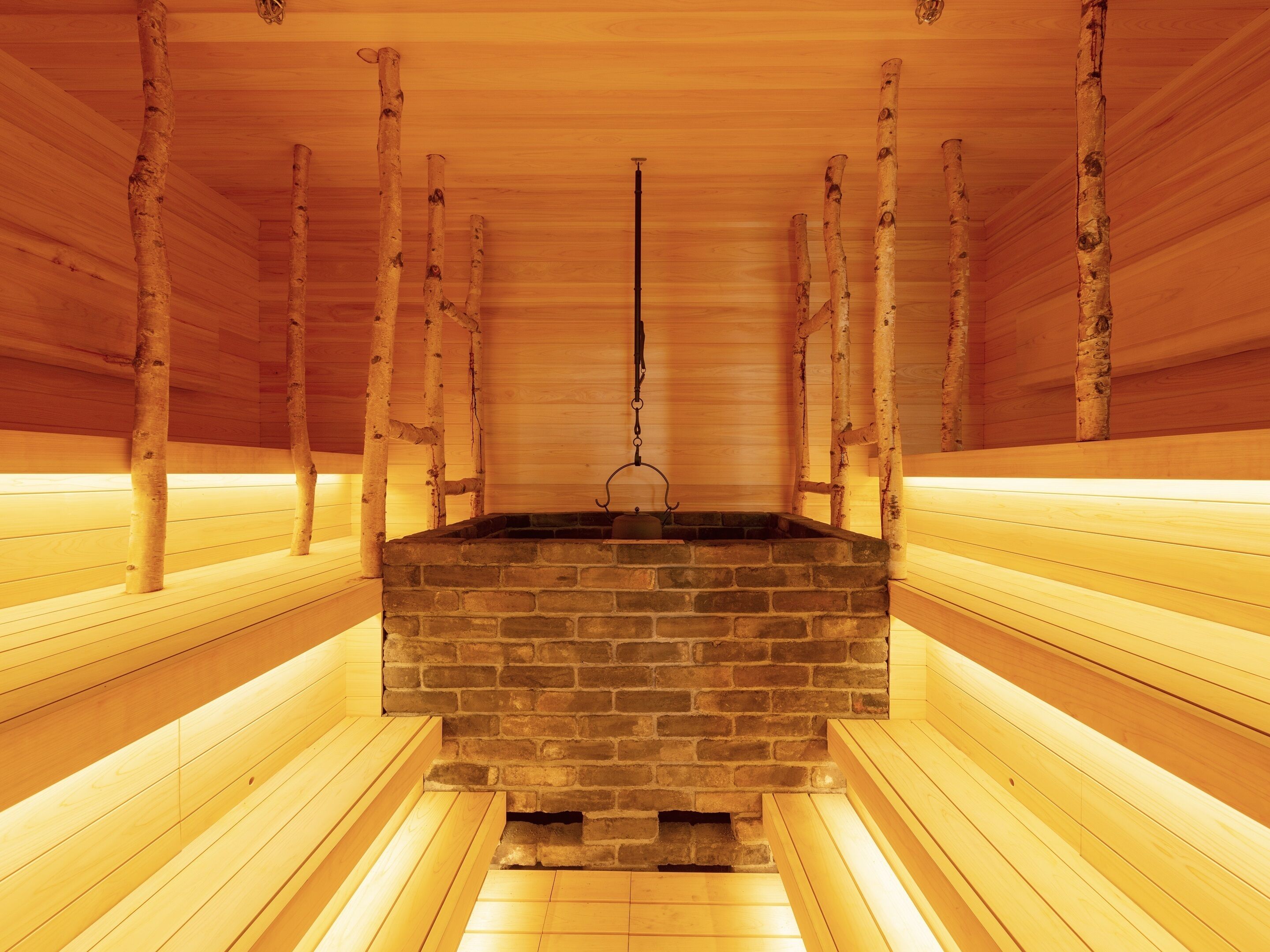 A sauna with wooden benches and a brick sauna room.