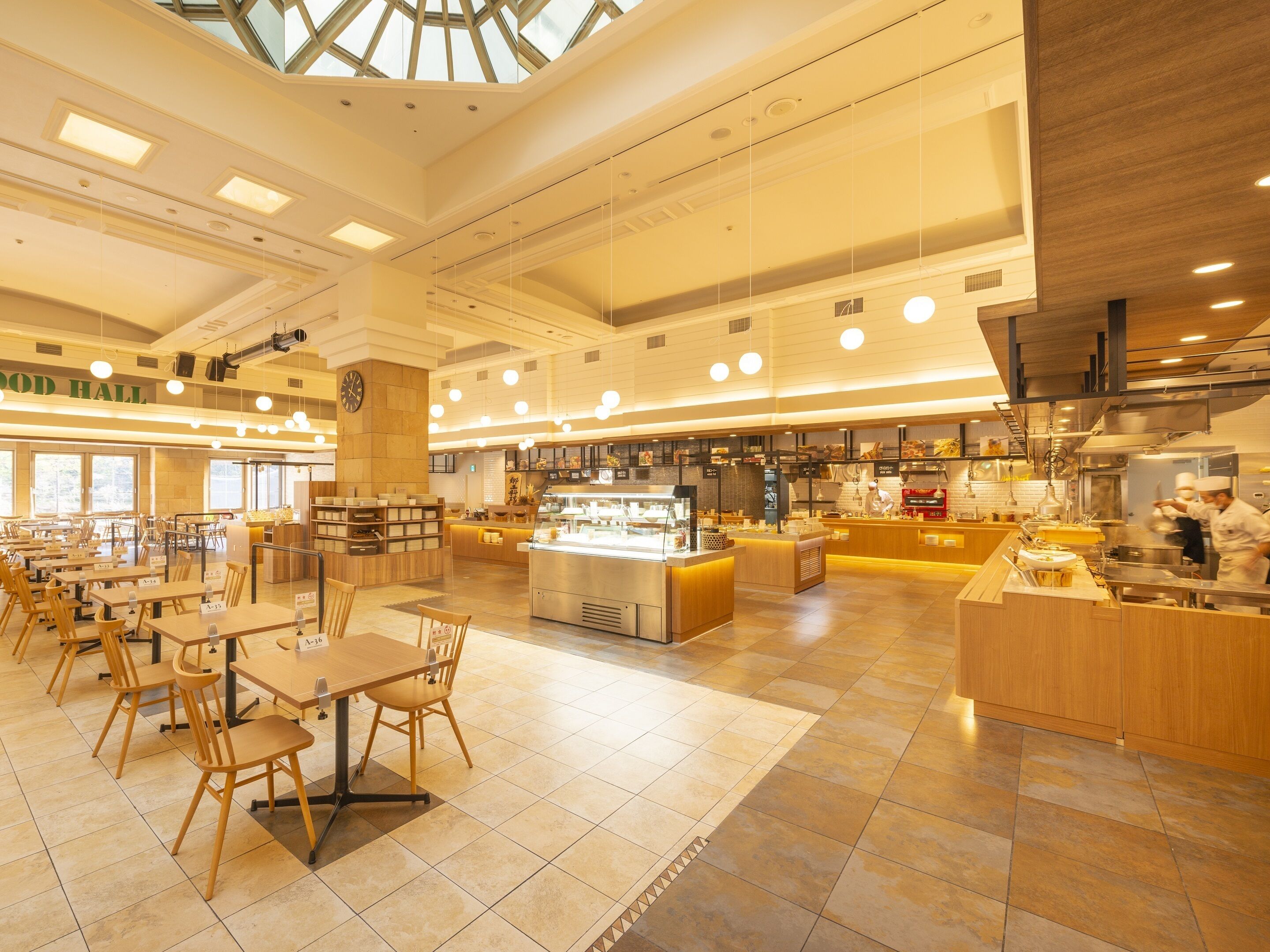 Een ruime foodhall met diverse eetgedeeltes, een centrale balie en een zichtbare keuken.
