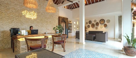 A spacious lobby with a reception desk, seating area, and decorative wall art.