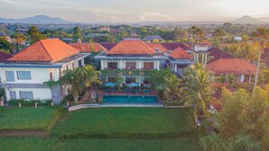 Un gran complejo turístico con varias edificaciones, piscina y exuberante vegetación.