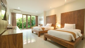 Una habitación de hotel moderna con dos camas de madera, un escritorio de madera y un ventanal con vistas a zonas verdes.