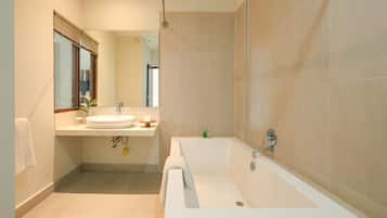 Un baño moderno con una bañera grande, un lavabo y un espejo.