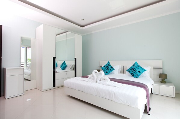 A modern bedroom with a large bed, a wardrobe, and a mirror. - Hidden Palm Pool Villas (Pattaya)