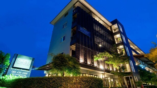 A modern hotel with a prominent sign, multiple floors, and a well-lit facade. - Ploen Pattaya Residence by Tolani (Pattaya)