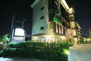 A multi-story hotel with a well-lit entrance and a signboard. - Ploen Pattaya Residence by Tolani (Pattaya)