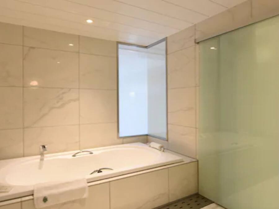 A modern bathroom with a freestanding bathtub, a glass shower enclosure, and a large mirror.
