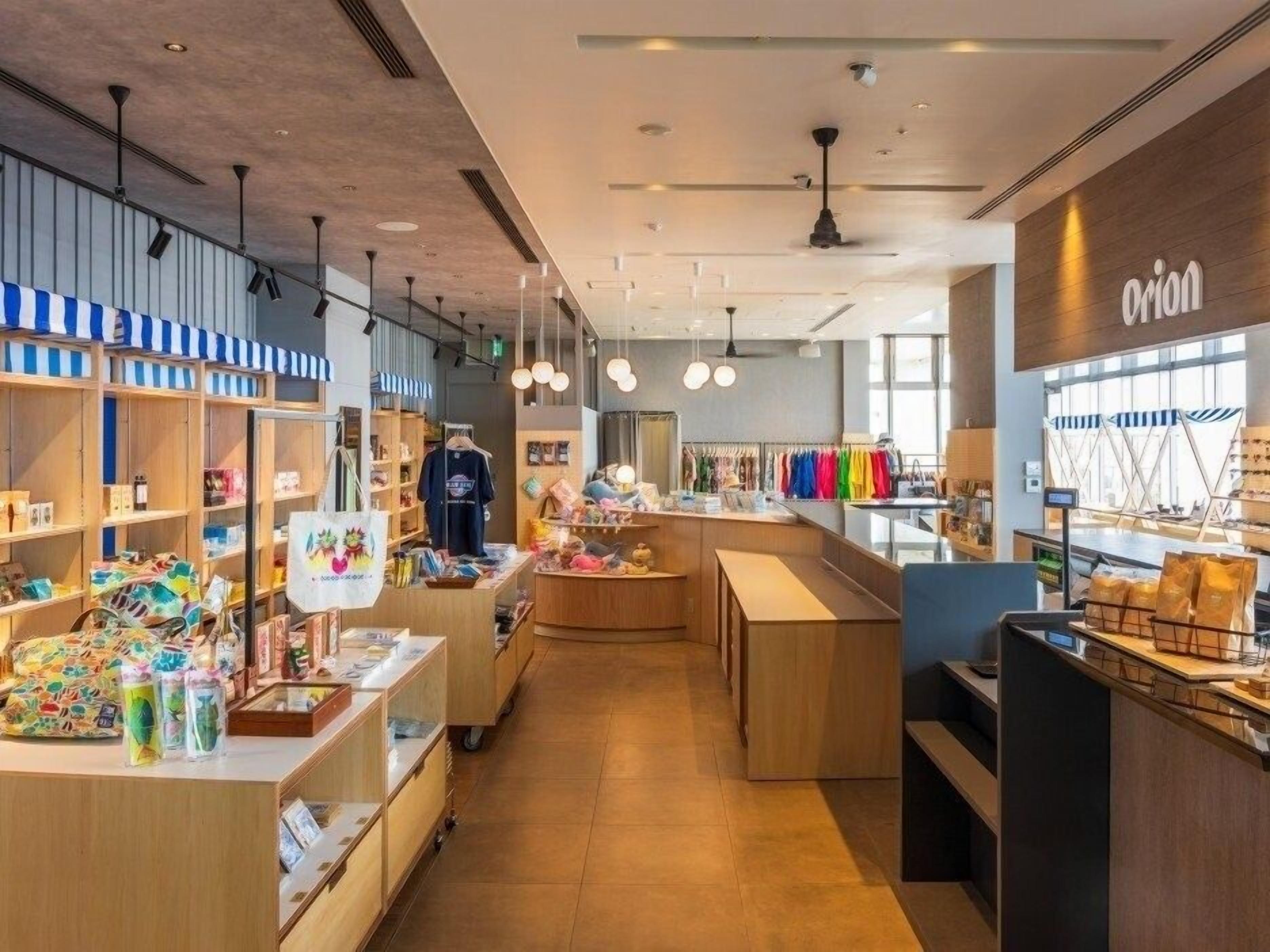 A modern retail store interior with wooden shelves, a central counter, and a visible brand sign.