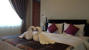 A hotel room with a bed, a headboard, a wall-mounted artwork, and a window with curtains. - Cozy Boutique Hotel (Phnom Penh)