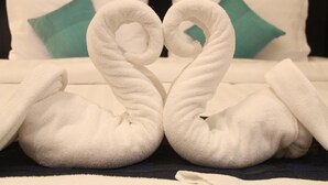 A bed with white linens and teal pillows. - Cozy Boutique Hotel (Phnom Penh)
