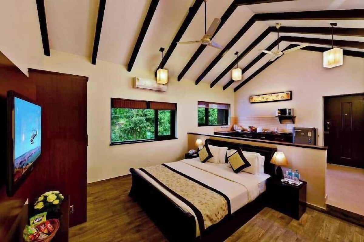 Un dormitorio con cama, mesita de noche, televisión y vistas al exterior.