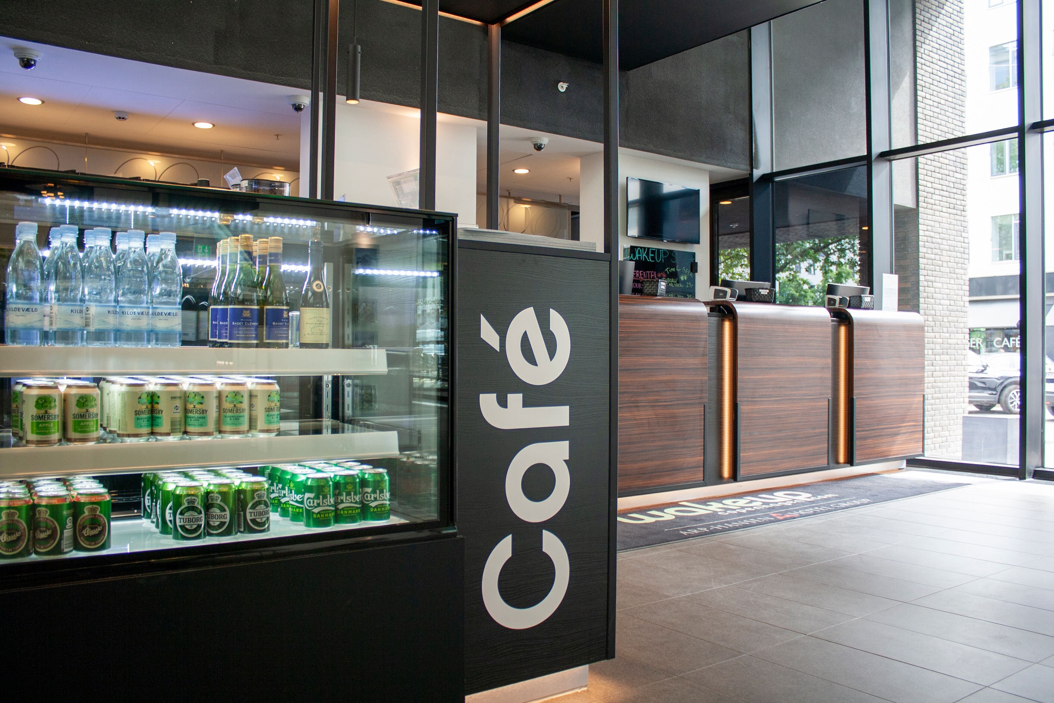 A café with a glass display case containing bottled water and canned beverages.