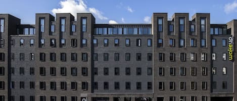 A modern multi-story building with a uniform facade, large windows, and a flat roof.