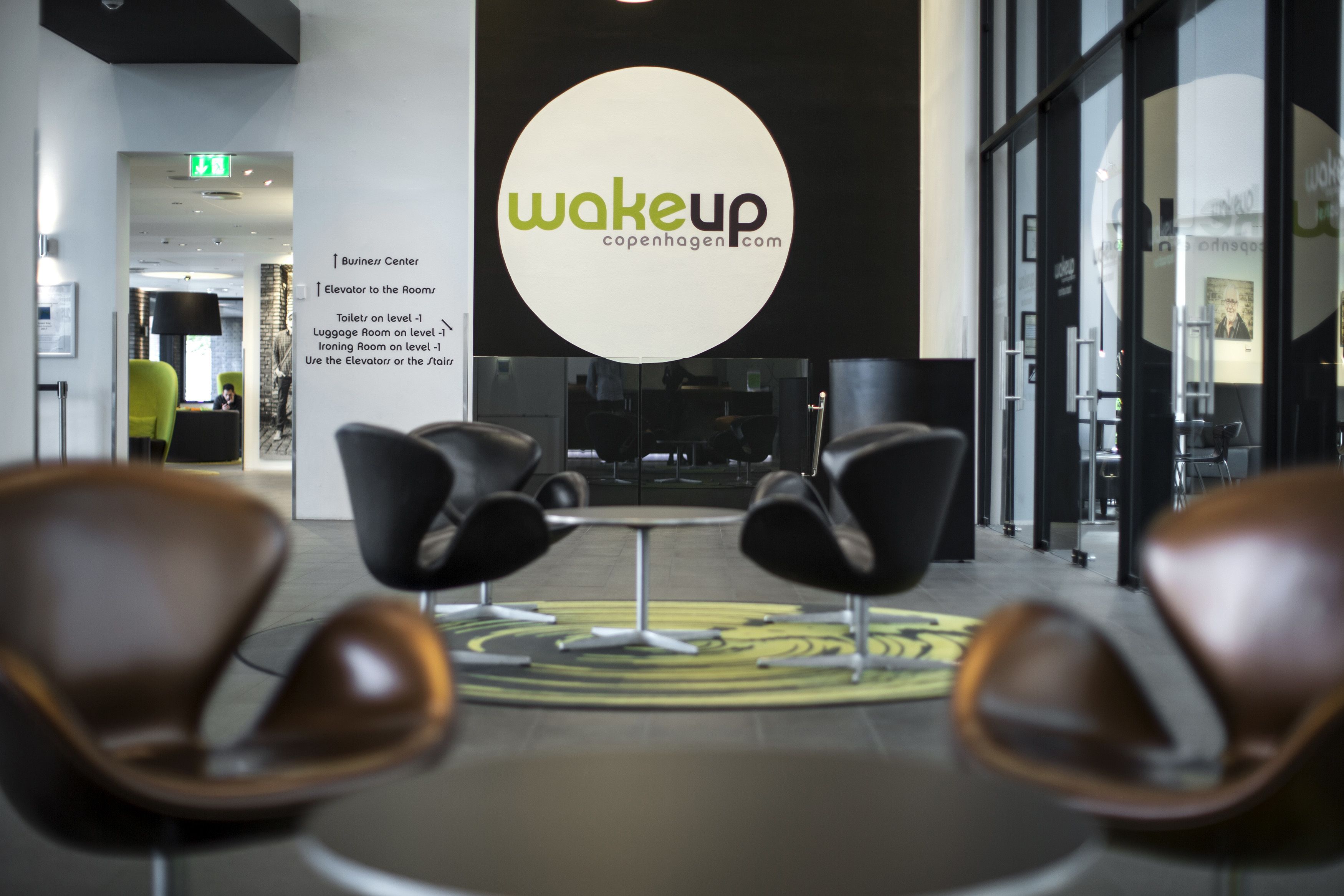A modern interior with a central logo, seating area, and directional signage.