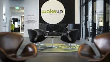 A modern interior with a central logo, seating area, and directional signage.