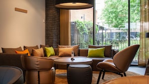 A modern living room with a sectional sofa, a round coffee table, and a leather armchair.
