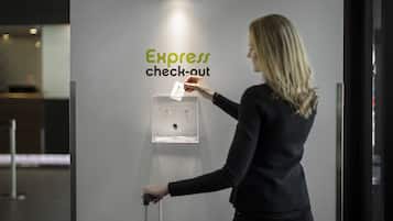 A person using an express check-out machine in a hotel lobby.