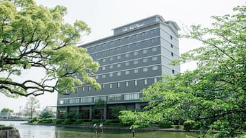 A multi-story hotel with a modern design, located near a body of water.
