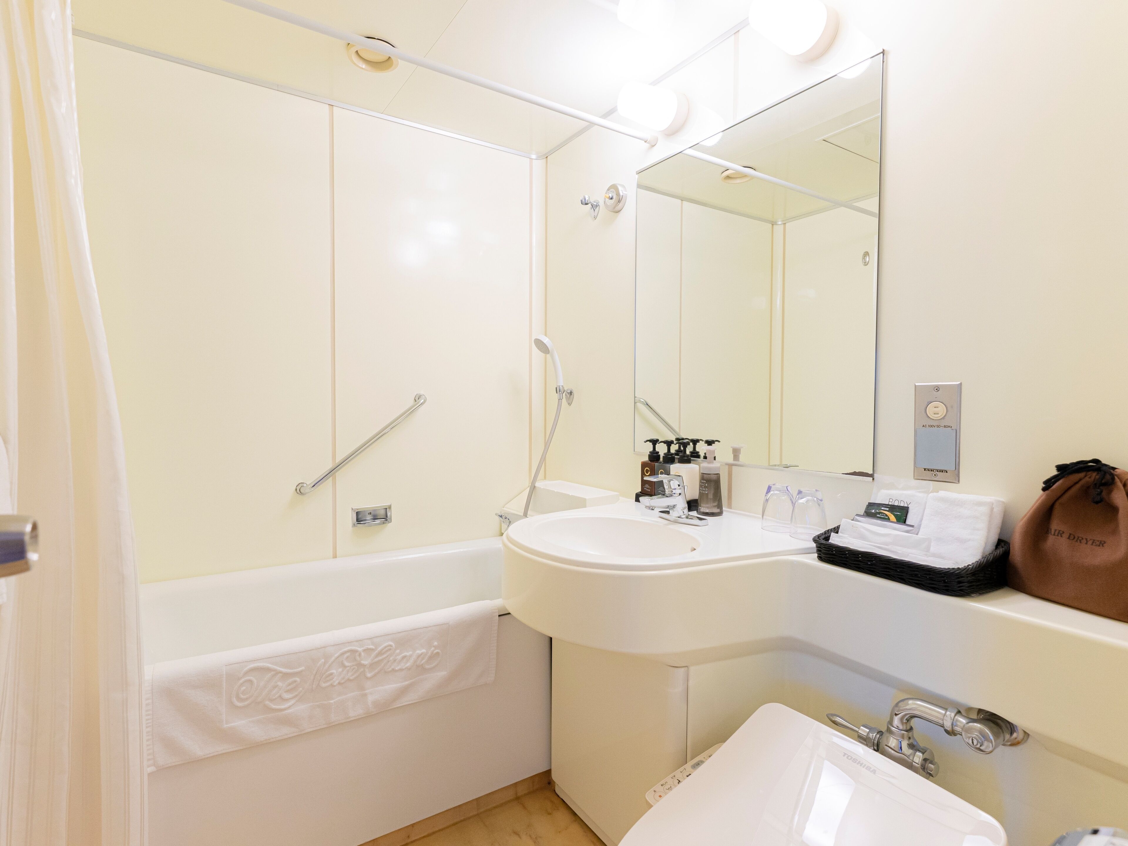 A modern bathroom with a bathtub, a sink, and a mirror.